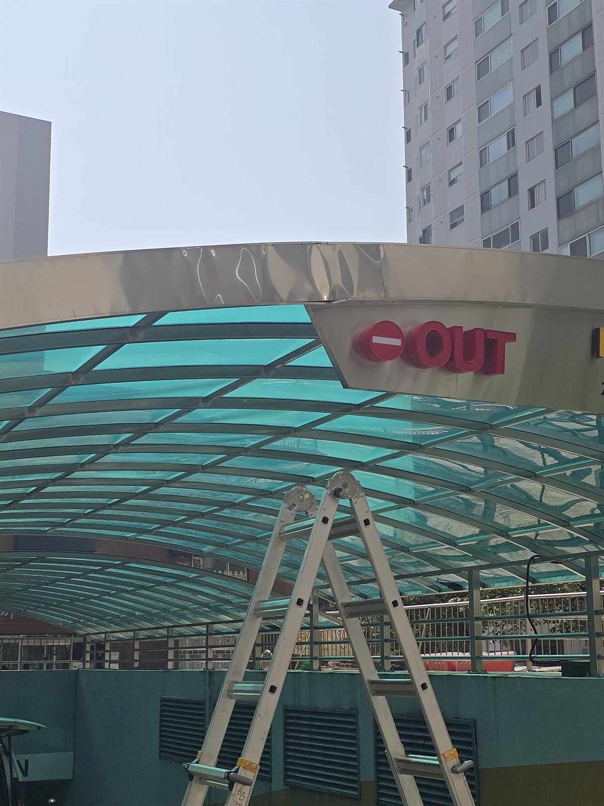 지하주차장 입구 캐노피 처마 마감판이 눌려 물결처럼 변형된 시공 전 상태
